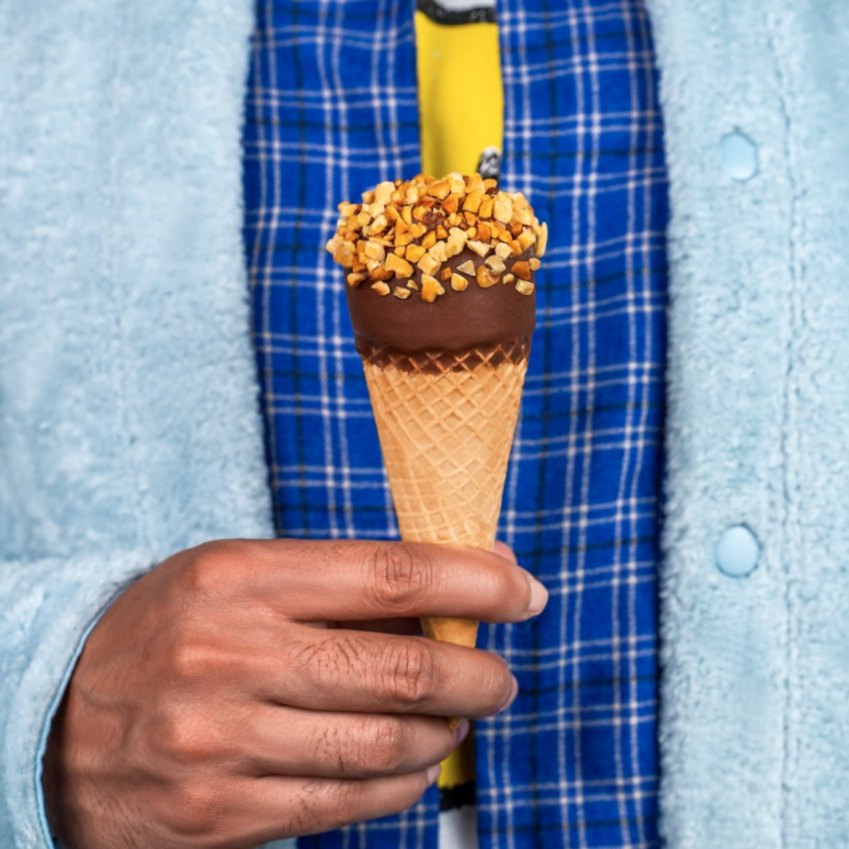 A closeup of someone holding up a Drumstick Classic Cone. 