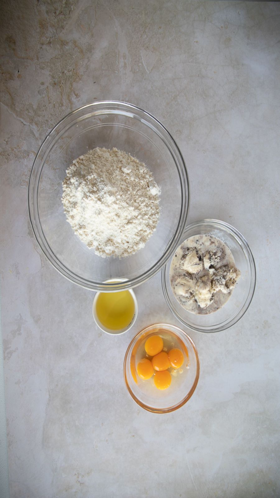 Edy's or Dreyer's Cookies 'N Cream Frozen Dairy Dessert, olive oil, eggs, and flour in individual bowls.