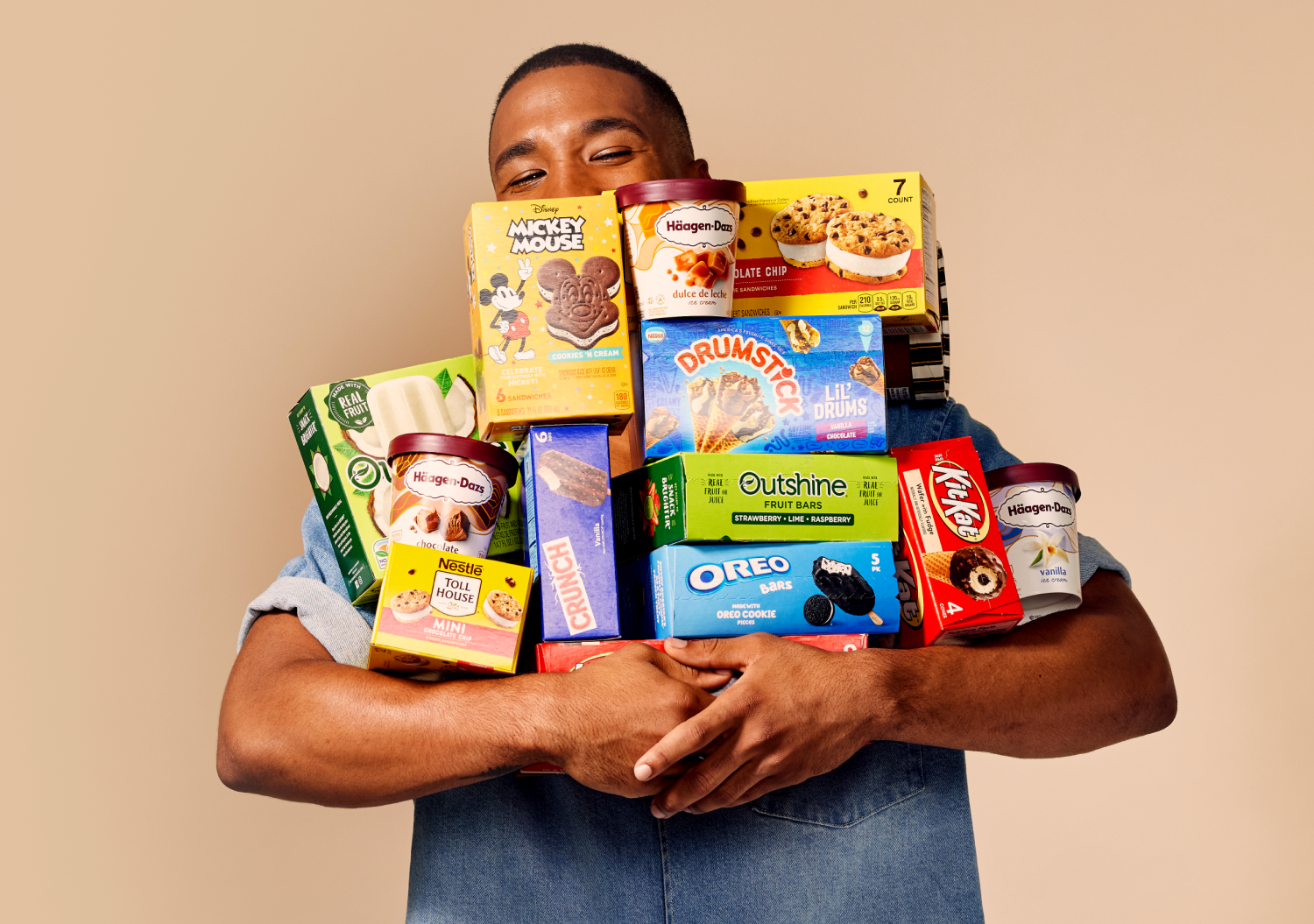 A man holding a large armful of various Dreyers products. 