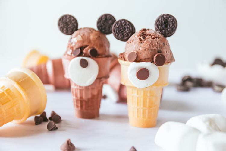 Two ice cream cones made to look like teddy bears with their decorations. 
