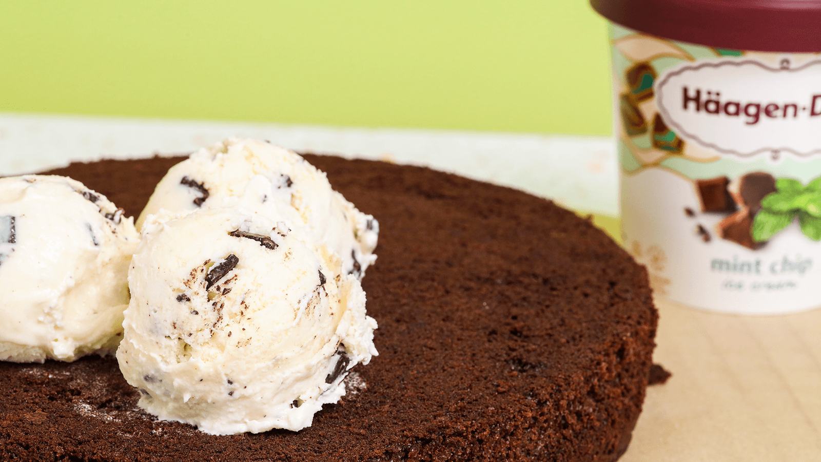 Base of chocolate cake with servings of Haagen Dazs Mint Chocolate Chip Ice Cream on top of it.