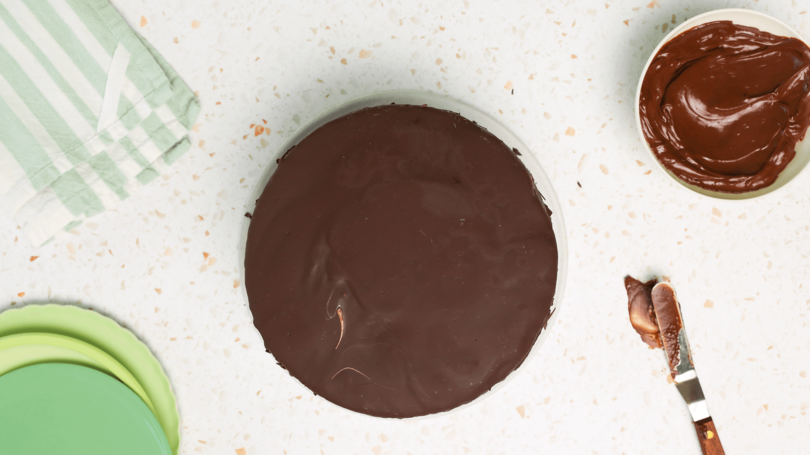 Mint Chocolate Chip Ice Cream Cake with Chocolate fudge frosting covering it.