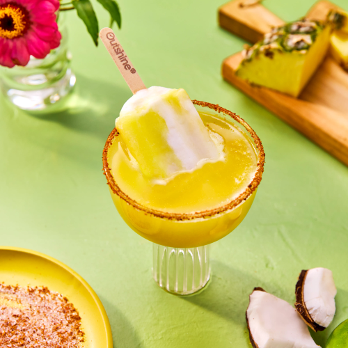 Pineapple and coconut drink topped with an Outshine Frozen Fruit Bar. 