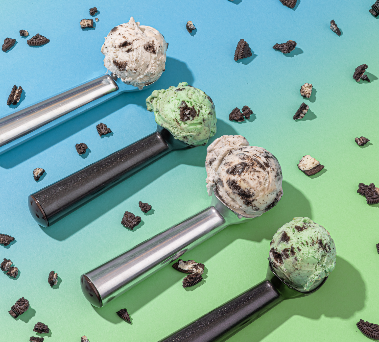 Four ice cream scoops each with a scoop of different ice cream. 